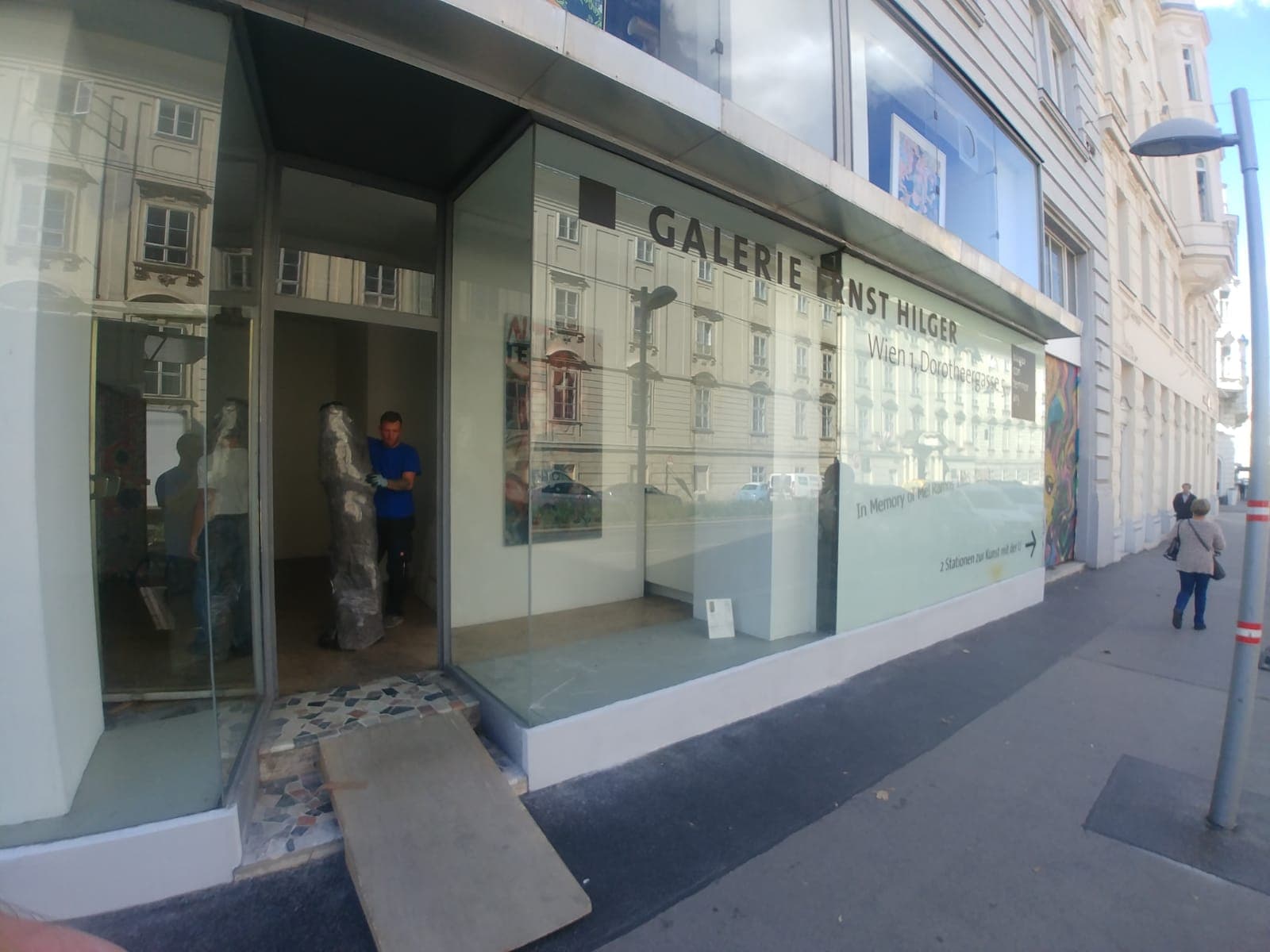 Mitarbeiter trägt ein verpacktes Kunstobjekt in eine Galerie