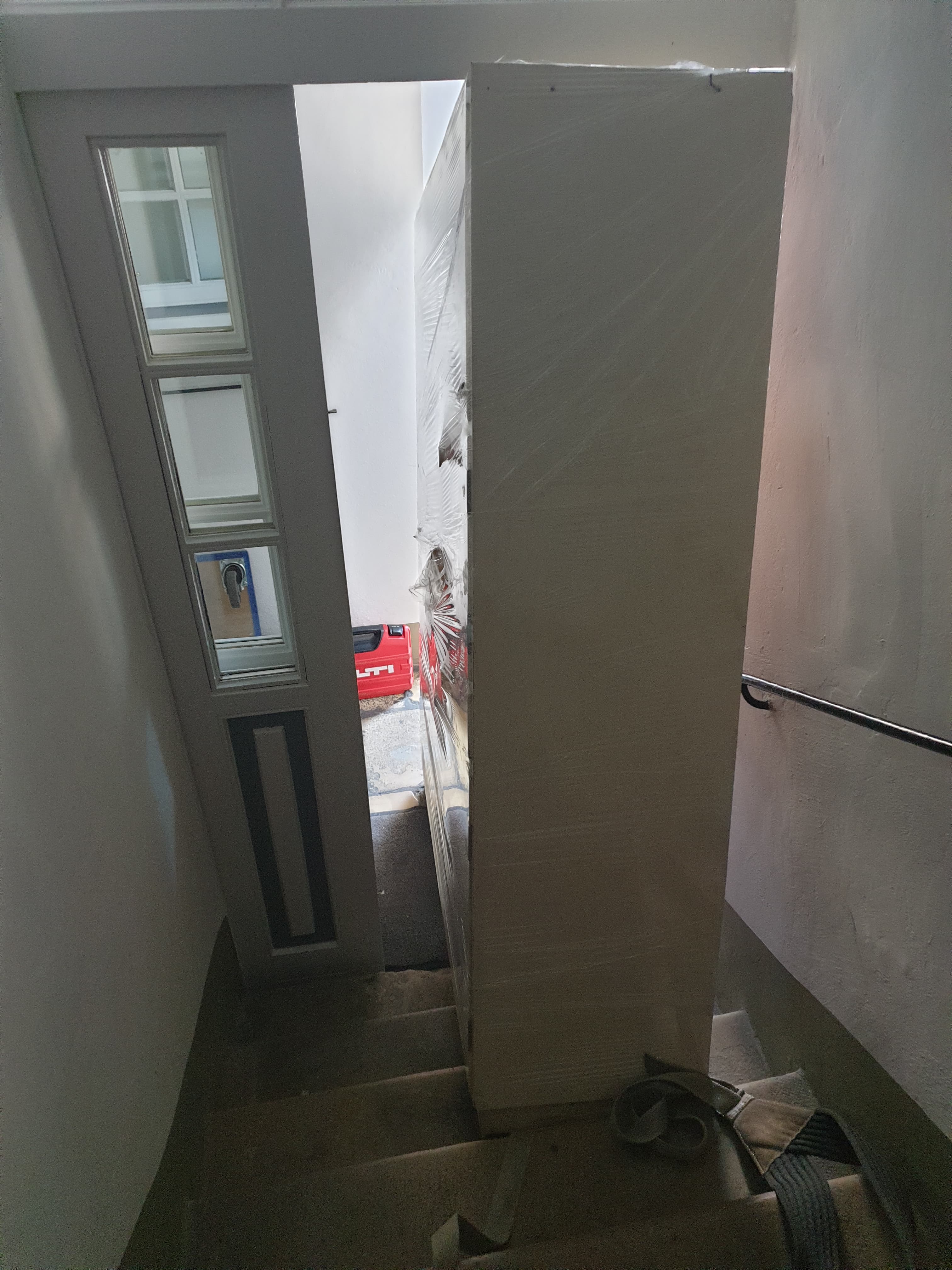 Ein großer, verpackter Schrank steht eng im Hauseingang